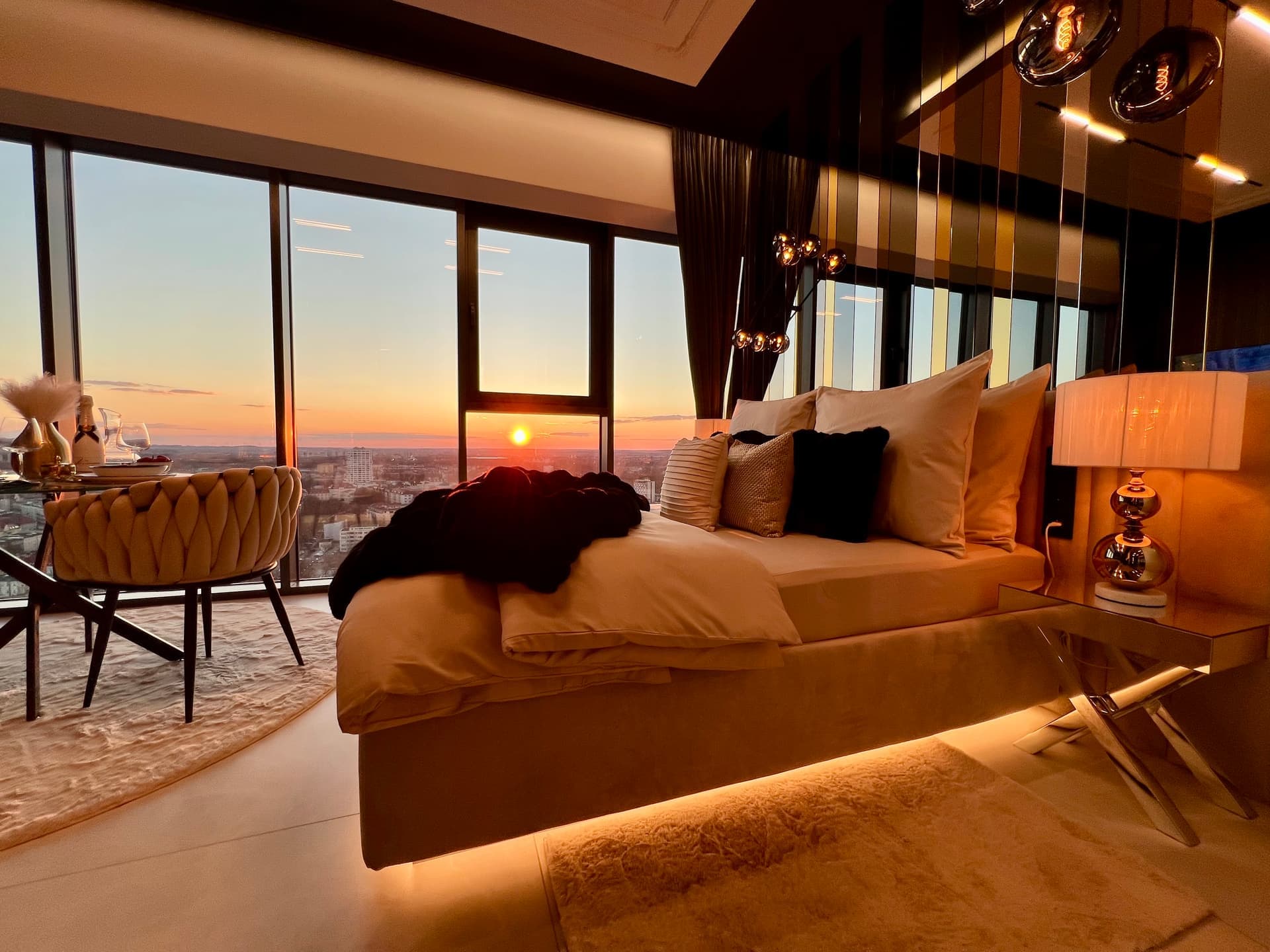 Suite wide view with bed, dining area and floor-to-ceiling windows in daylight