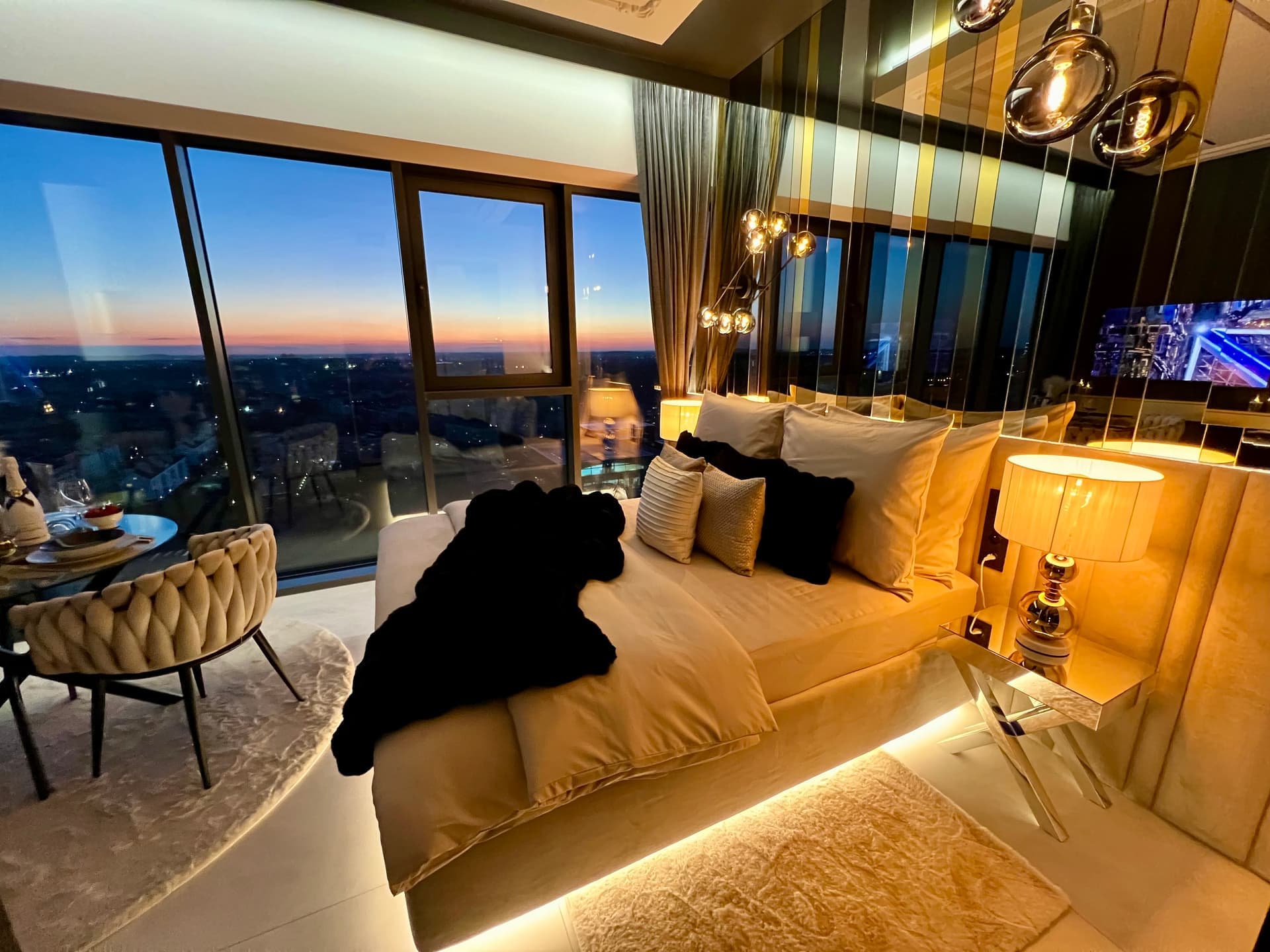 Bedroom with king-size bed and sunset view through panoramic windows