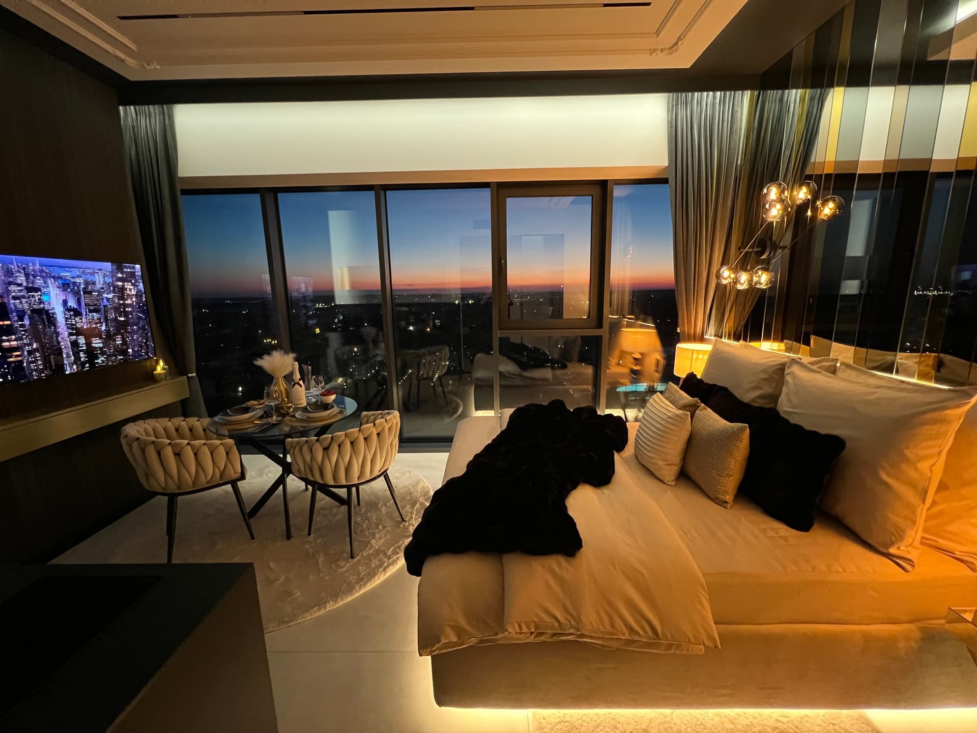 Suite at dusk with bed, set table and pink-to-blue gradient sky