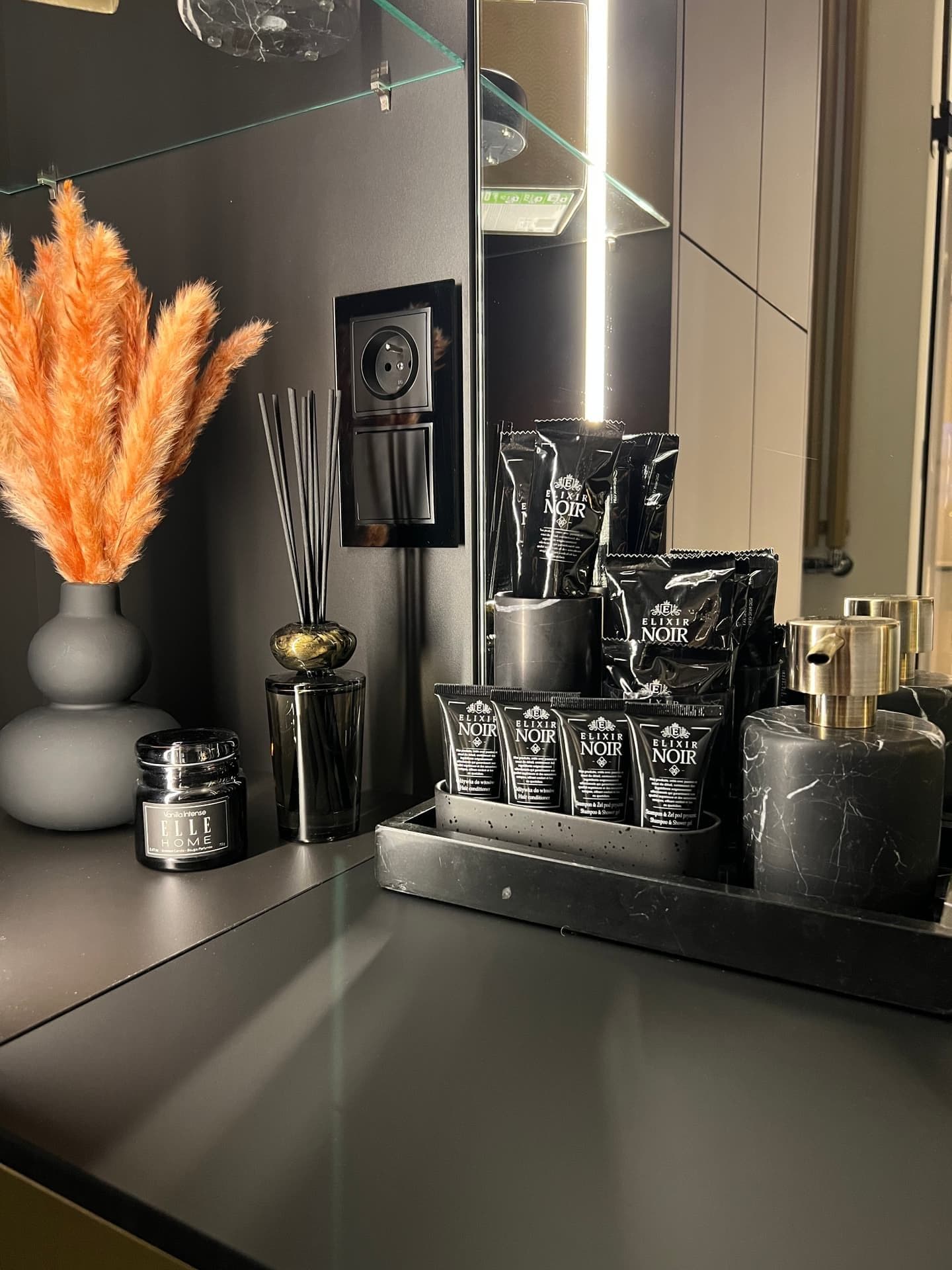Luxury amenities: Elixir Noir products, reed diffuser and Elle Home candle