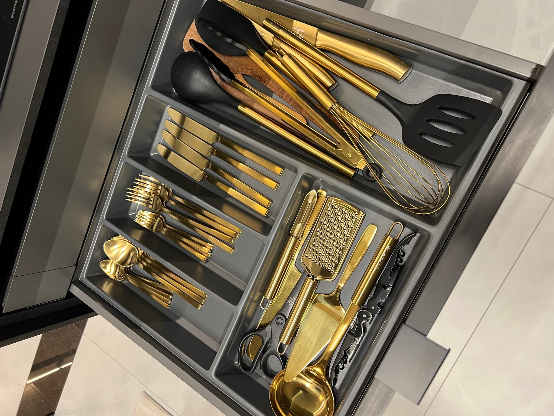 Kitchen drawer with gold cutlery and cooking utensils