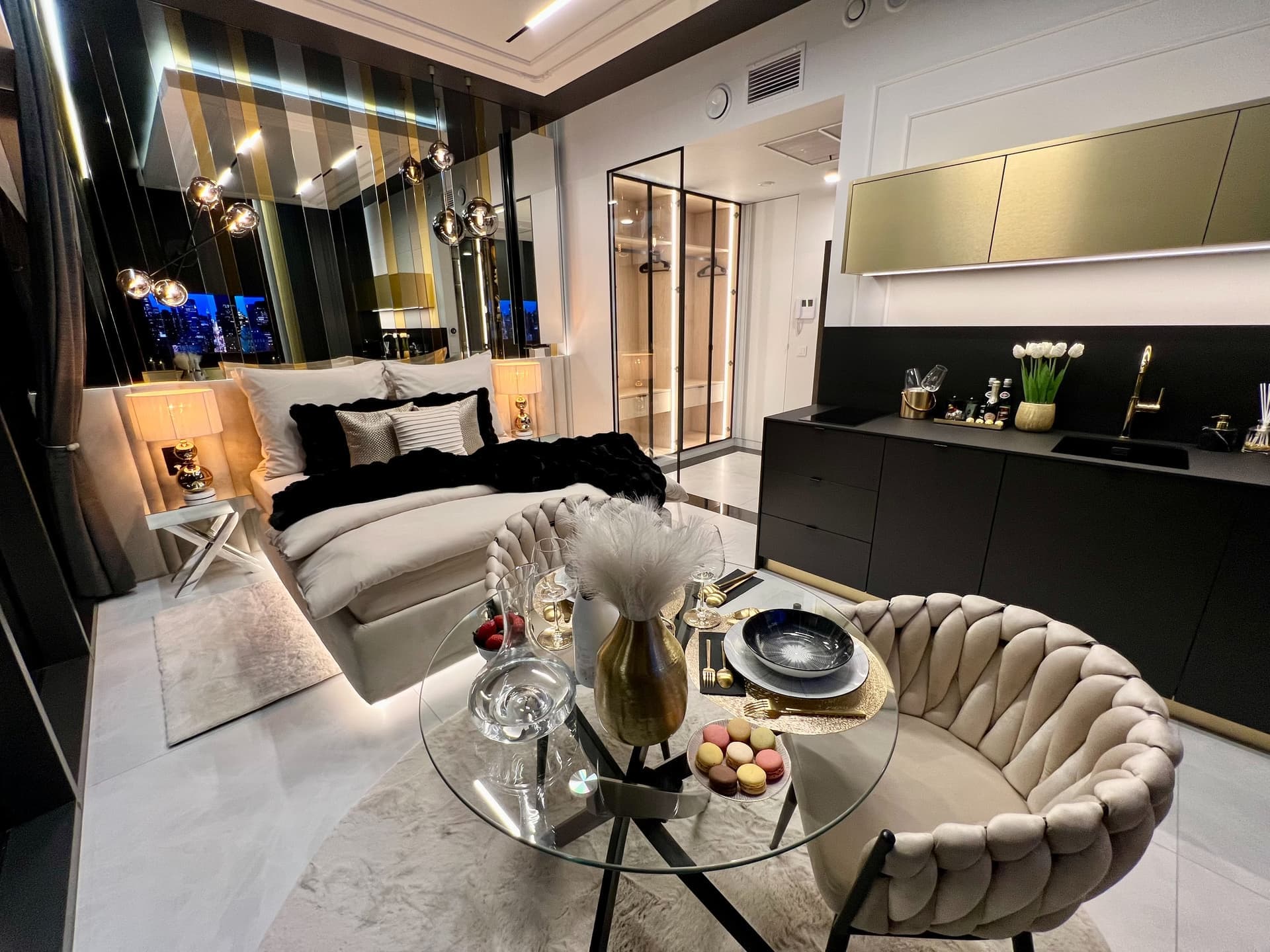 Night overview: bed, dining area, kitchenette and glass-walled bathroom