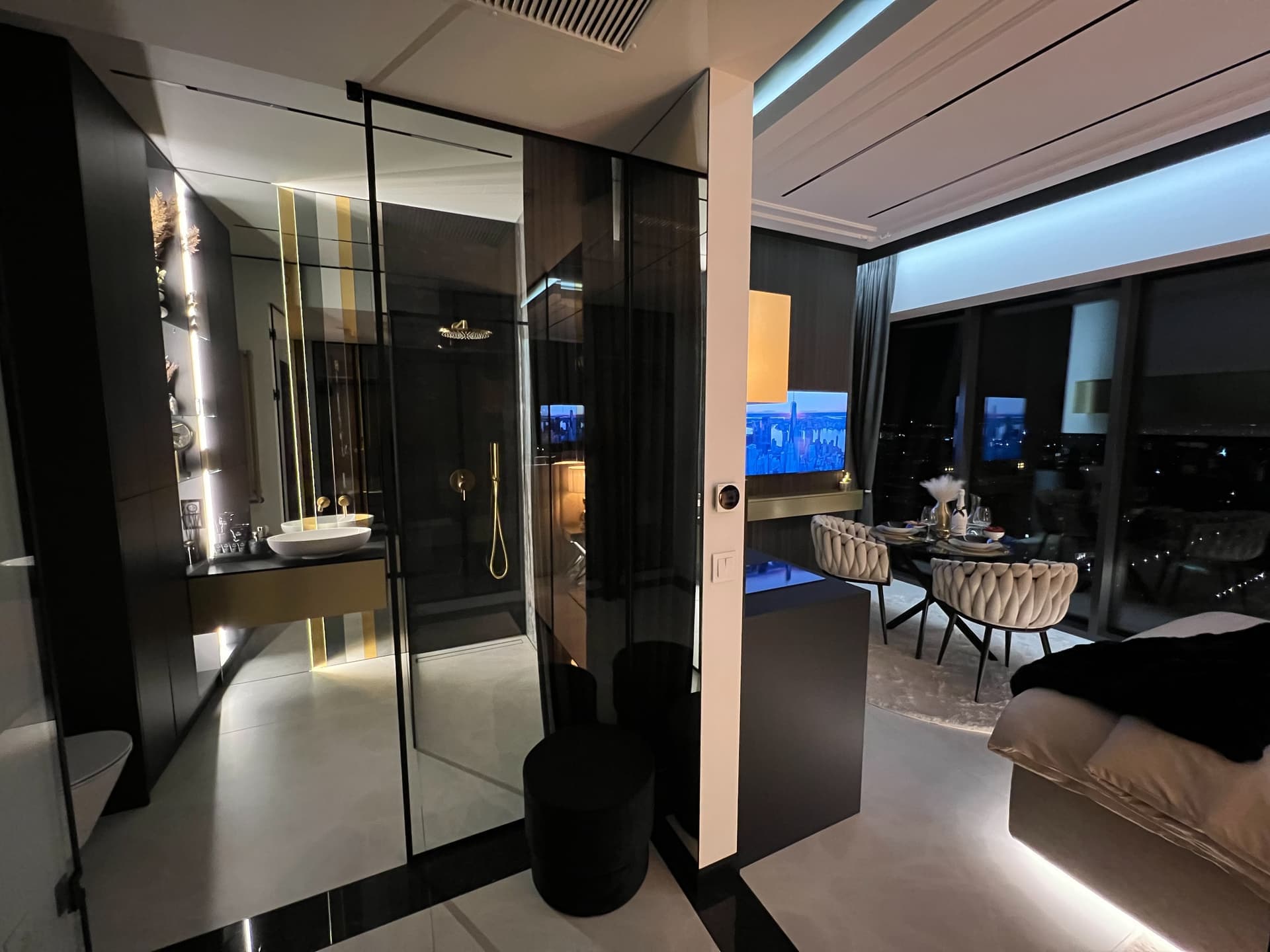 Night view of suite with illuminated bathroom and living space